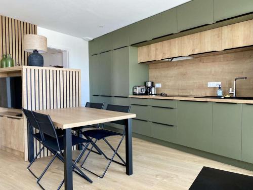 une cuisine avec une table et des chaises en bois dans l'établissement Corsaire Saint Gilles Croix de Vie, à Saint-Gilles-Croix-de-Vie