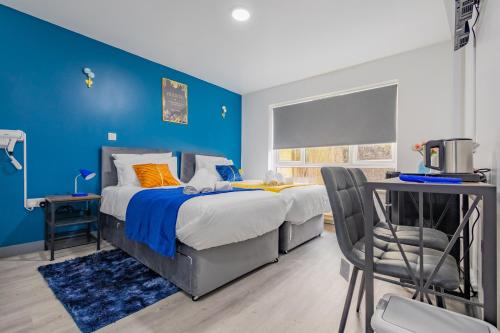 a blue bedroom with a bed and a chair at Premium Serviced Accommodation Rooms Nottingham - All with Ensuites in Nottingham