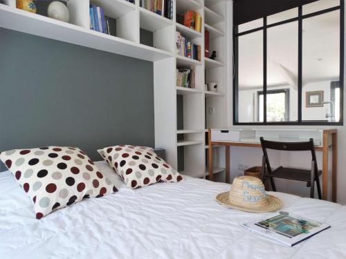 Transat Saint Gilles Croix de Vie في سانت جيل كروا دي فيي: غرفة نوم مع سرير مع قبعة عليه