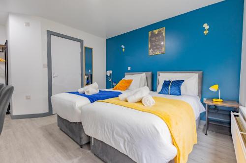 two beds in a room with blue walls at Premium Serviced Accommodation Rooms Nottingham - All with Ensuites in Nottingham