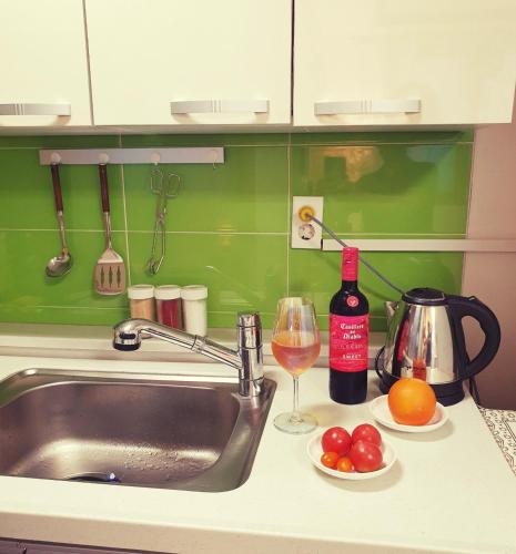 a kitchen counter with a sink and a glass of wine at Luna Casa in Daegu