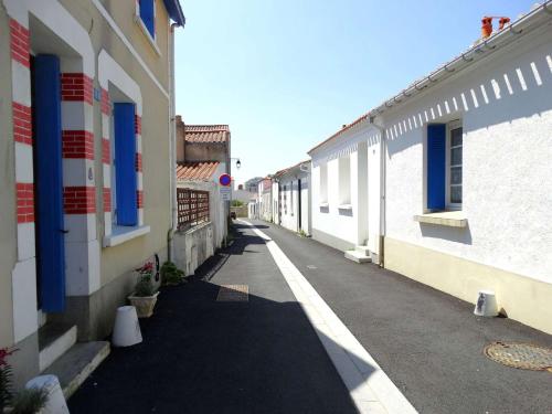 an empty alley between two buildings with blue windows at Horizon Saint Gilles Croix de Vie in Saint-Gilles-Croix-de-Vie
