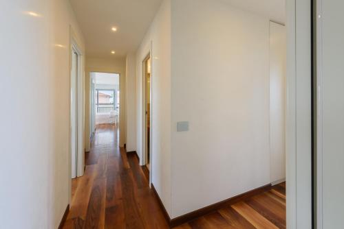 an empty hallway with white walls and wood floors at Golden Luxe - Panoramic Penthouse Rooftop whit Pool in Lido di Camaiore