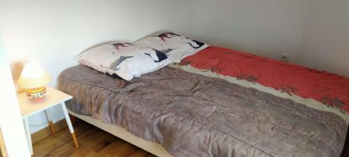 un lit dans une pièce à côté d'une table avec une lampe dans l'établissement L'évasion Littorale de Sion - Saint Hilaire de Riez, à Saint-Hilaire-de-Riez