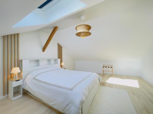 une chambre blanche avec un grand lit blanc et une fenêtre dans l'établissement Le Luxury Lodge - 8 Voyageurs - Parking et Wifi, à Mulsanne