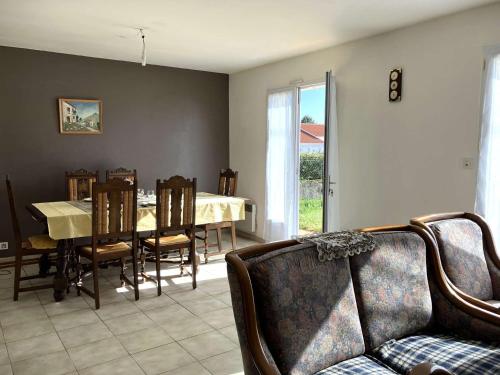 un salon avec une table, des chaises et un canapé dans l'établissement La Bussolerie de la mer - Saint Hilaire de Riez, à Saint-Hilaire-de-Riez