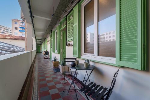 d'un balcon avec une table, des chaises et des fenêtres. dans l'établissement Appartement Ostave - Welkeys, à Nice