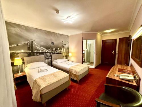 a hotel room with two beds and a painting on the wall at Cumulus Hotel in Będzin