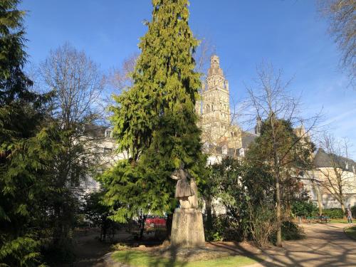 une statue devant un arbre devant un bâtiment dans l'établissement LEBIS, a deux pas de la cathédrale, à Tours