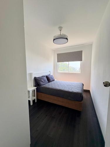 a small bedroom with a bed and a window at 92 Camarque - 3 Bedroom Apartment With Amazing Sea Views In Umdloti in Umdloti