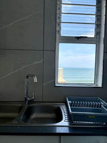 a kitchen sink with a window and a tray at 92 Camarque - 3 Bedroom Apartment With Amazing Sea Views In Umdloti in Umdloti