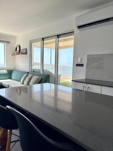 a kitchen with a counter top and a living room at 92 Camarque - 3 Bedroom Apartment With Amazing Sea Views In Umdloti in Umdloti