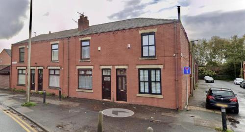 a brick building with a car parked in front of it at Ideal 3 bed pay-as-you-stay home in Wigan sleeps 6 in Wigan