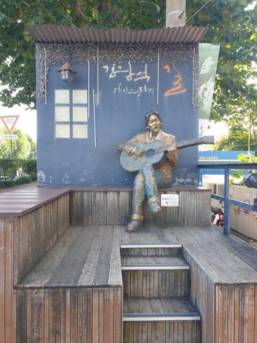 a statue of a man playing a guitar on a building at Luna Casa in Daegu