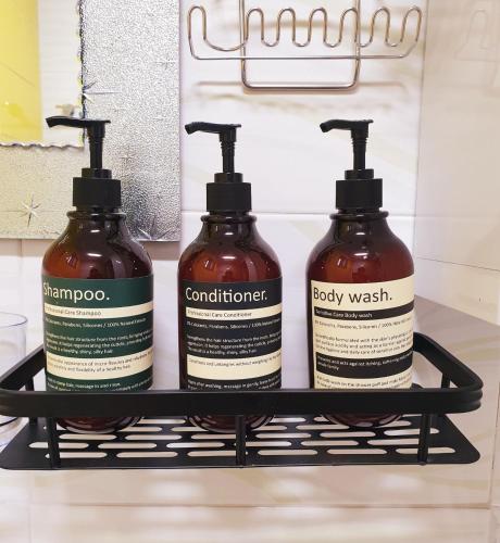 three bottles of shampoo and conditioner on a shelf at Luna Casa in Daegu