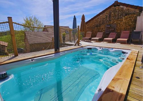 a swimming pool with blue water in a backyard at Bien-être & Spa privatif - Spa de nage, sauna, lit hydromassant & relaxation Immersive in Saint-Jean-Ligoure