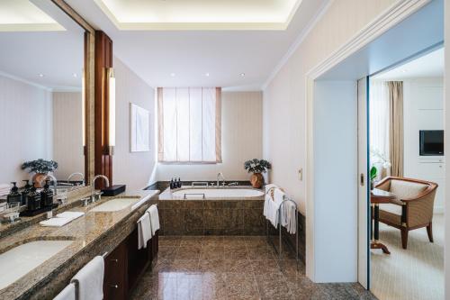 a bathroom with two sinks and a bath tub at Hotel Nassauer Hof in Wiesbaden