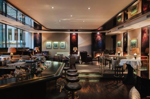 a restaurant with a bar with chairs and tables at Hotel Nassauer Hof in Wiesbaden