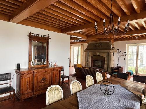 a living room with a fireplace and a table and chairs at Château Philip in Saint-Genest-Lerpt