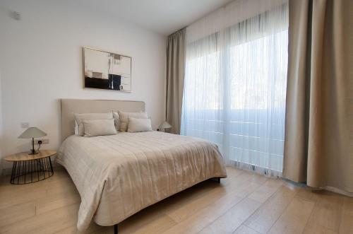 a bedroom with a bed and a large window at DownTown Villa 2 in Paphos
