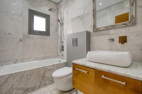 a bathroom with a sink and a toilet and a tub at DownTown Villa 2 in Paphos