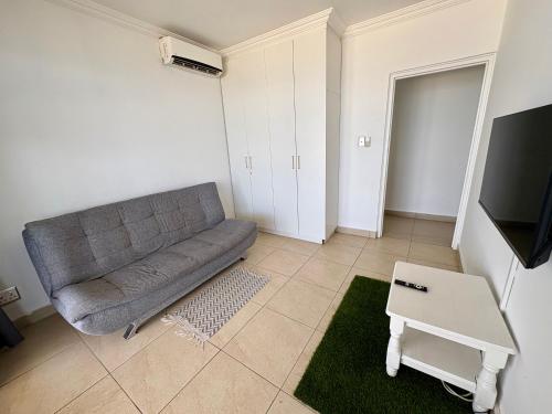 a living room with a couch and a tv at 101 Camarque - 3 Bedroom Apartment With Amazing Sea Views In Umdloti in Umdloti