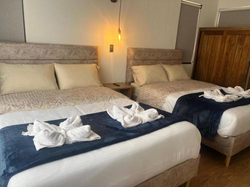 a hotel room with two beds with towels on them at Hotel Sol de la Montaña Villa de leyva in Villa de Leyva