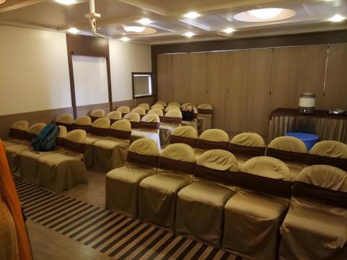 a room with rows of chairs in a room at New Hotel Europa Inn in Rajkot