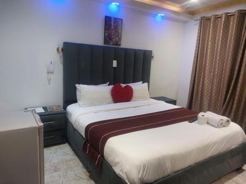 a bedroom with a bed with a red heart pillow on it at Gold Crown International Hotel With Complementary Breakfast and WiFi in Johannesburg