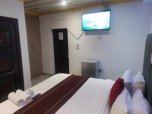 a bedroom with a bed with a flat screen tv on the wall at Gold Crown International Hotel With Complementary Breakfast and WiFi in Johannesburg