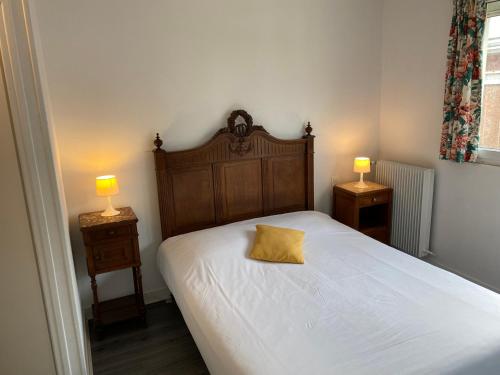 a bedroom with a bed with a yellow pillow on it at Hôtel Restaurant l'Annexe in Saint-Valéry-en-Caux