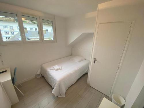 a small white bedroom with a bed and a window at Hôtel Restaurant l'Annexe in Saint-Valéry-en-Caux