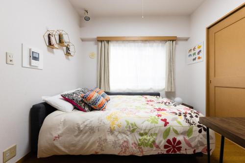 a bedroom with a bed with a flowered blanket at SHIBUYA Bright Modern 40sqm Apartment FAMILY FRIENDLY!! in Tokyo