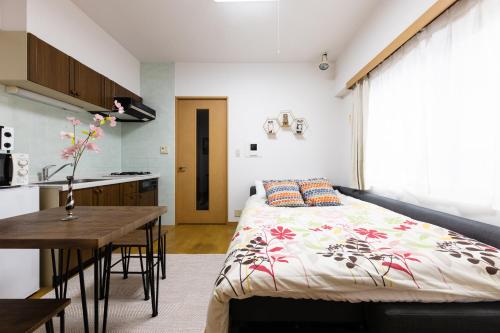 a bedroom with a bed and a table and a kitchen at SHIBUYA Bright Modern 40sqm Apartment FAMILY FRIENDLY!! in Tokyo