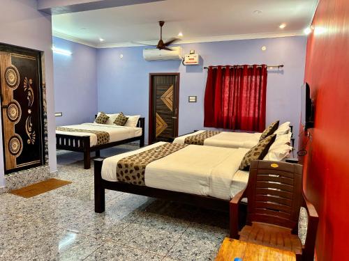 una habitación de hotel con dos camas y un sofá en Le Oasis Auro'Ra, en Pondicherry