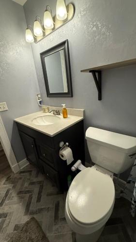 a bathroom with a toilet and a sink with a mirror at Kris Jordan in Palm Bay