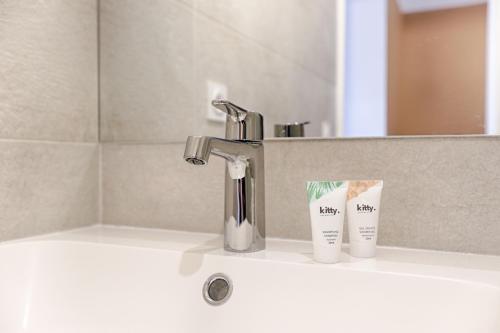 - un lavabo avec un robinet et 2 tasses dans l'établissement Mykeypers - Studio Cozy 2P - Malakoff 11, à Malakoff