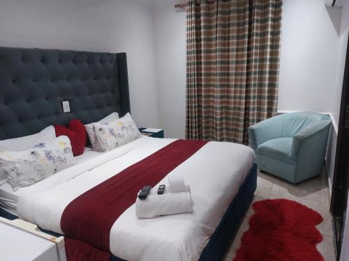 a bedroom with a large bed and a blue chair at Gold Crown International Hotel With Complementary Breakfast and WiFi in Johannesburg