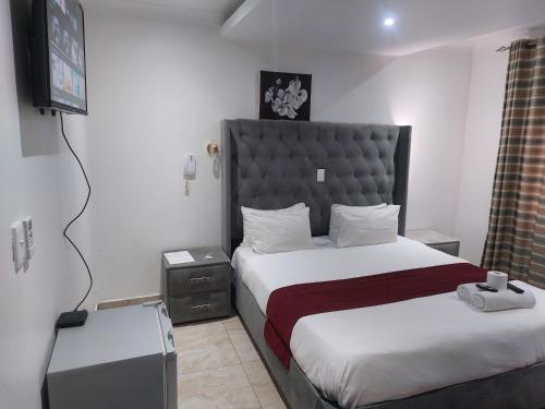 a hotel room with a bed and a television at Gold Crown International Hotel With Complementary Breakfast and WiFi in Johannesburg