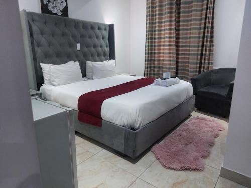 a bedroom with a large bed and a chair at Gold Crown International Hotel With Complementary Breakfast and WiFi in Johannesburg