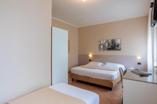 a hotel room with two beds and a window at Al Centro in Verbania