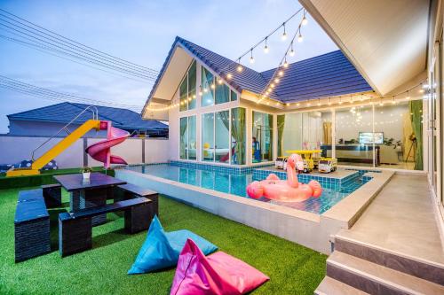 a house with a pool with a slide and a playground at M4 Billion Pool Villa Cha-am in Cha Am