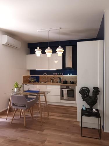 une cuisine avec une table et une salle à manger dans l'établissement Appartement T2 40 m2 rue du casino centre-ville climatisé 1 chambre balcon, à Aix-les-Bains