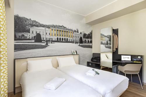a bedroom with a white bed and a desk at B&B Hotel Como City Center in Como