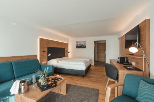 a hotel room with a bed and a couch at Alpen Resort & Spa in Zermatt