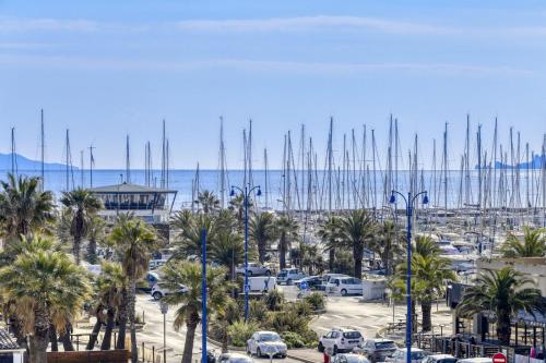 un parking avec des palmiers et un port de plaisance avec des bateaux dans l'établissement Beau Studio Vue Mer, à Hyères