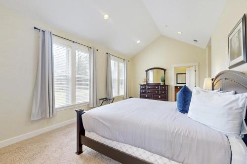 a bedroom with a large white bed and windows at Fairway and Far Away in Seaside