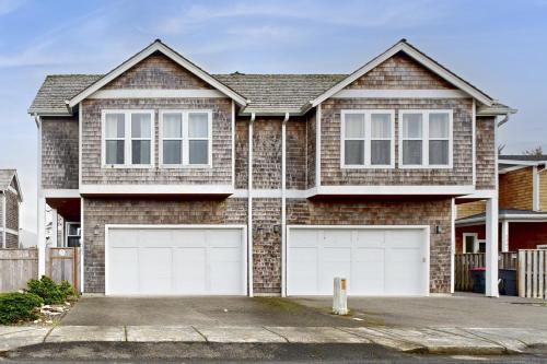 a brick house with two white garage doors at Fairway and Far Away in Seaside