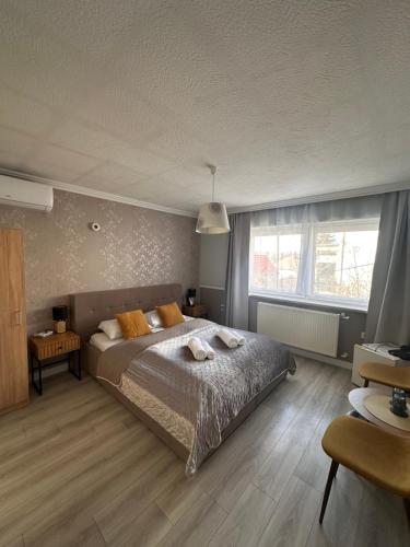 sypialnia z łóżkiem i dużym oknem w obiekcie Jager Guesthouse w mieście Sopron