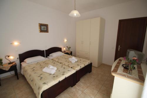a bedroom with a large bed with towels on it at zorbas apartment deluxe in Moraitika